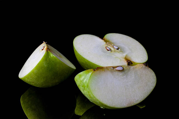 istock Sliced green apple on black from side 500478494