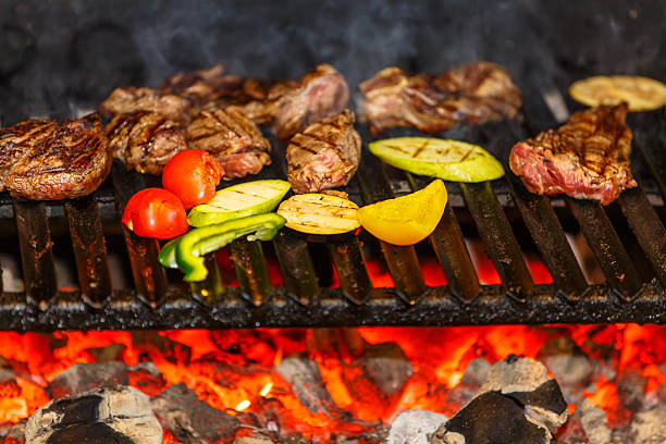 istock Meat and vegetables are roasted on a grill over coals. 500478878