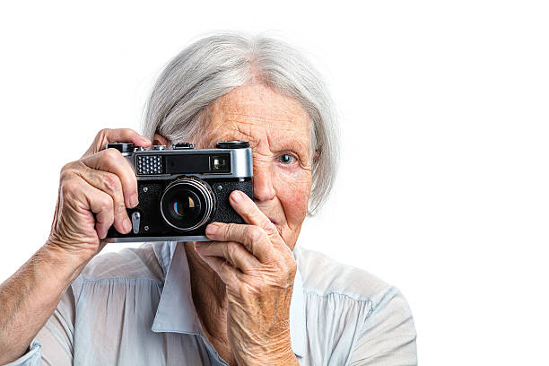 istock Senior woman shooting with a retro camera 500479428