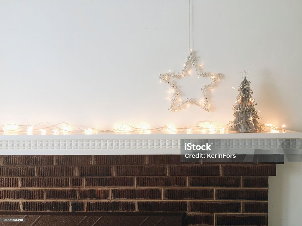 Christmas decorations Silver Christmas trees, star and lights Mantelpiece Stock Photo