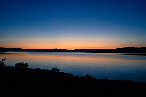 Sunset at Kielder water, aka, Kielder reservoir, Northumberland National Park.  The orange tinge is captured in the water.