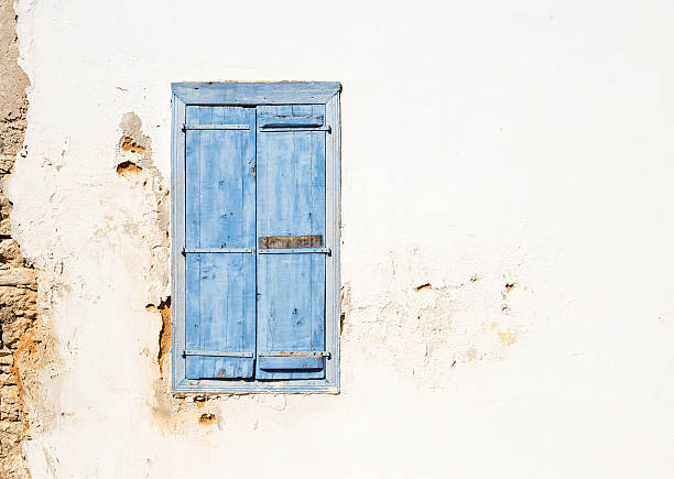 mediterrâneo estilo antigo janela. azul na parede com luz fechado - greece blue house wall imagens e fotografias de stock