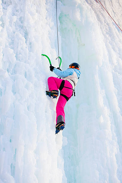 istock Woman climbing frozen waterfall 500485316