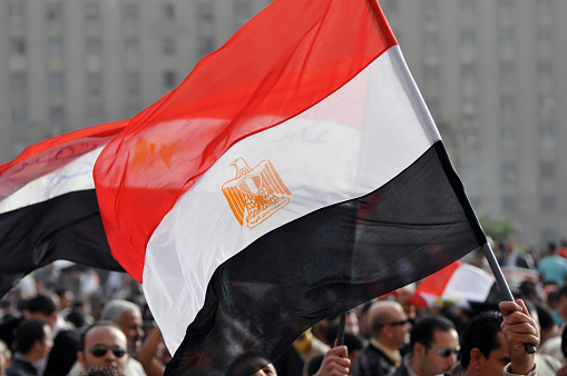 An Egyptian flag is held above in Cairo's Tahrir Square at a rally two weeks after the resignation of President Mubarak.