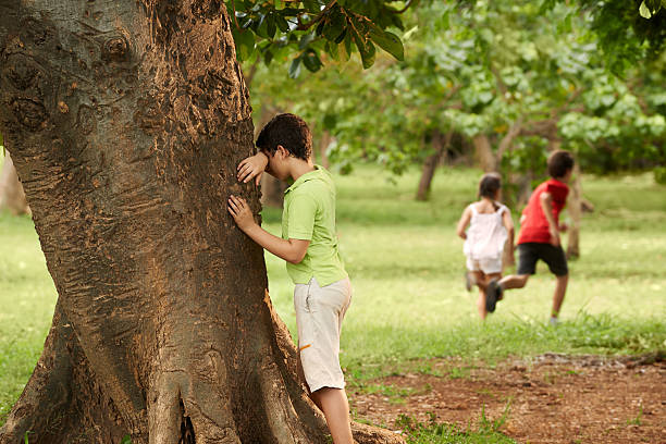 group of children playing hide and seek stock photo