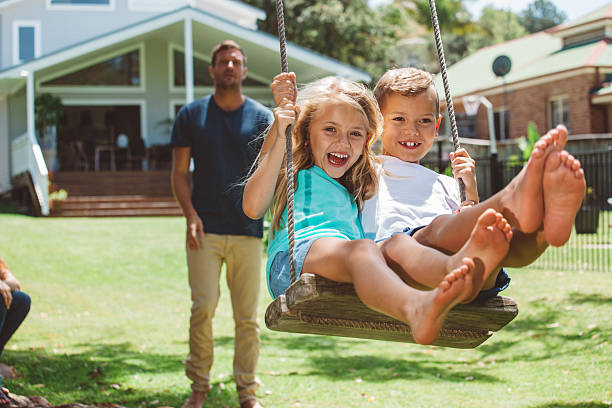 familia jugando al aire libre - columpio de cuerda fotografías e imágenes de stock