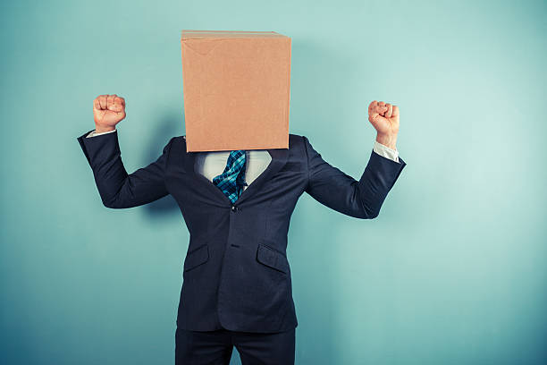 istock Triumphant businessman with box on head 500495229