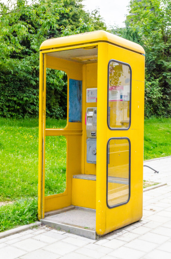 An old yellow telephone booth of the Deutsche Bundespost.