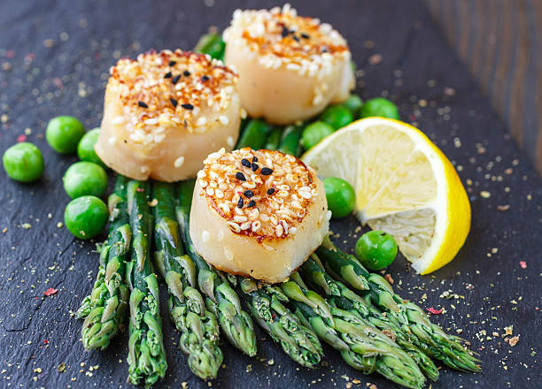 istock Fried scallops with sesame seeds, asparagus  and  lemon 500504154
