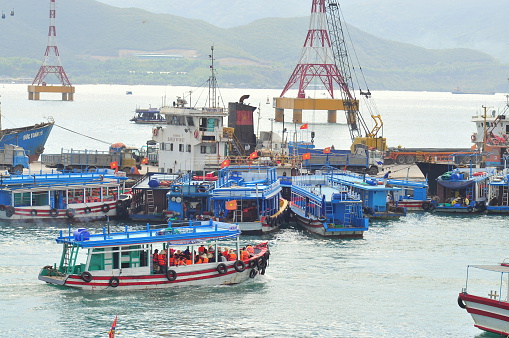 Nha Trang, Vietnam - July 13, 2015: Nha Trang, Vietnam - July 13, 2015: Boats are transfering travellers from the dock to island