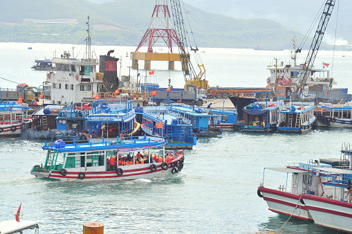 Nha Trang, Vietnam - July 13, 2015: Nha Trang, Vietnam - July 13, 2015: Boats are transfering travellers from the dock to island