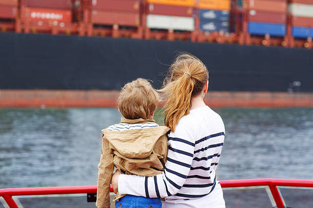 Little boy and mother watching ships on a ferry. Little son and his mother watching ships on a ferry river swimming women water stock pictures, royalty-free photos & images