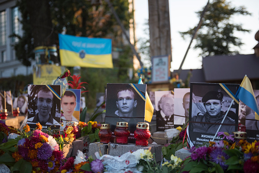  Kiev, Ukraine - September 14, 2015: A memorial with flowers, Ukrainian flags, and photos of those killed during the 2014 Euromaidan protest is located near Maidan Nezalezhnosti, the central square in Kiev, Ukraine.