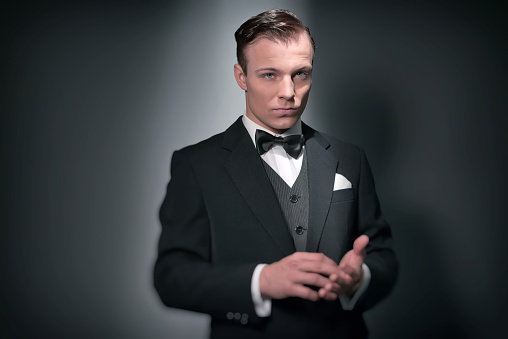 Retro 1920 business fashion man wearing black suit and bow tie. Studio shot.