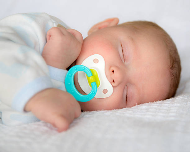 Baby sleeping peacefully with pacifier stock photo