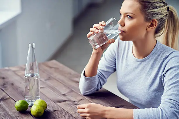 Young woman drinking water with lime in the morning