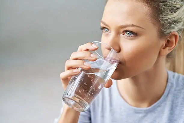 Beautiful young woman drinking mineral water