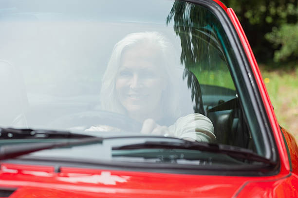 istock Cheerful mature woman driving red cabriolet 500521185