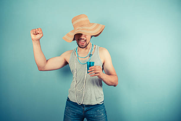 istock Happy young man wearing beach hat is drinking 500521985