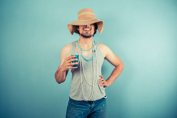 istock Happy young man wearing beach hat is drinking 500522005