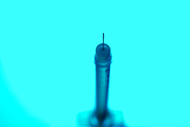 syringe close up on turquoise background stock photo