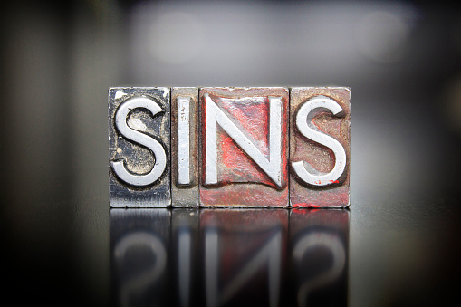 The word SINS written in vintage letterpress lead type
