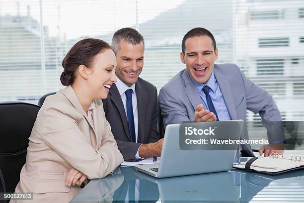 Cheerful Colleagues Working Together On Their Laptop Stock Photo - Download Image Now