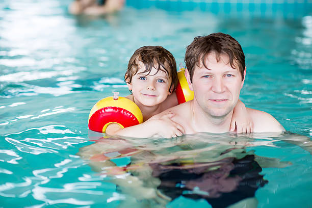 istock Young dad teaching his little son to swim indoors 500535444