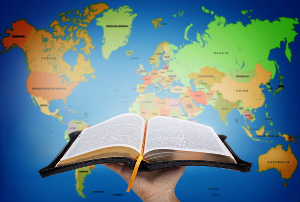The Great Commission Hand showing the Holy Bible against world map bible gospel stock pictures, royalty-free photos & images