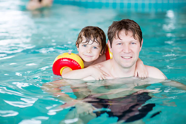 istock Young dad teaching his little son to swim indoors 500535940