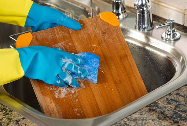 istock Cleaning Wooden Cutting board inside of Kitchen Sink with sponge 500537161
