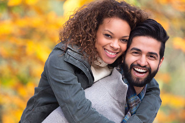 istock Mixed Race Couple Giving Each Other Piggy Backs 500537251