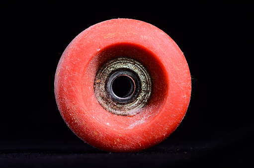 Old Vintage Consumed Skate Wheel on a Black Background