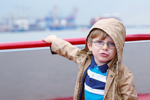 Little boy watching ships on a ferry.