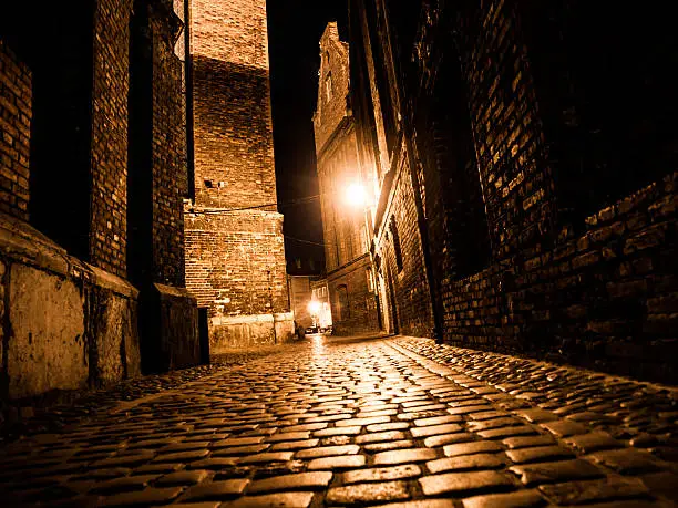 Photo of Illuminated cobbled street in old city by night