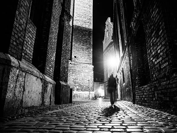 strada illuminata acciottolate della città vecchia di notte - black and white architecture surrounding wall wall foto e immagini stock