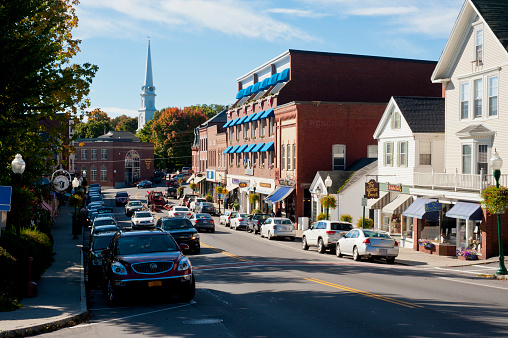 Wake Forest, NC-1 Dec 2022: Wide-angle street view of White Street on sunny autumn day, with senior male/female couple walking.  Businesses include Unwined and Re/Max.