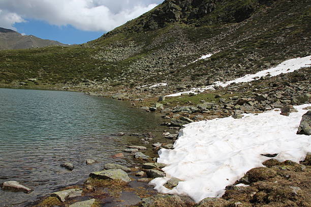 fusión de la nieve en el lago hirschebensee en primavera, kühtai, tyrol, austria - european alps tirol rhododendron nature fotografías e imágenes de stock