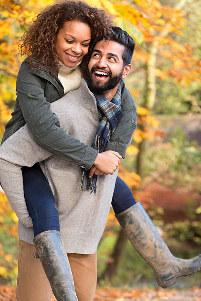 istock Mixed Race Couple Giving Each Other Piggy Backs 500552129