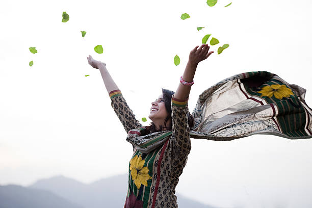 feliz joven mujer volando hacia el cielo leafs en el aire. - indian culture women india indian ethnicity fotografías e imágenes de stock