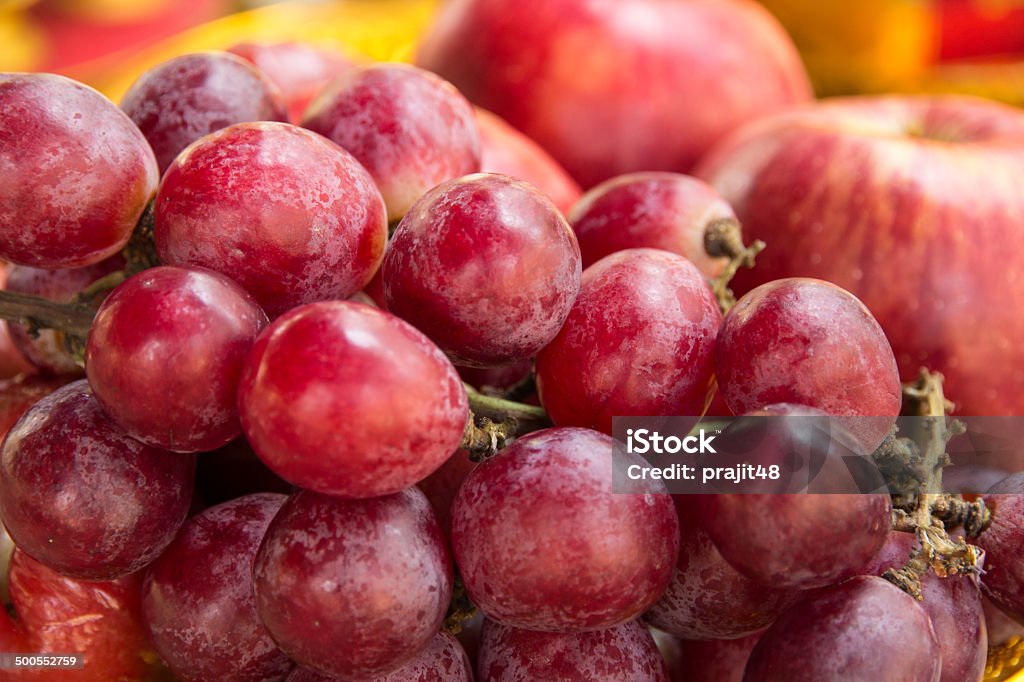 red grapes Close up of a large cluster of red grapes and apple Apple - Fruit Stock Photo