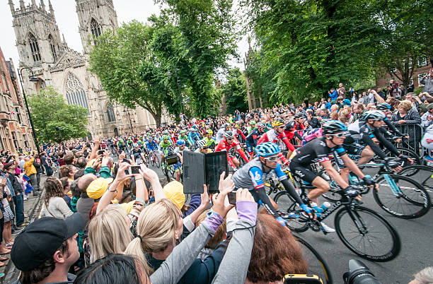 Tour de France peloton passing Minster in York, UK York, United Kingdom – July 6, 2014: People watch Tour de France peleton riding past York Minster in York, UK. 2014 stock pictures, royalty-free photos & images