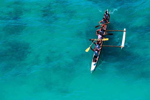 Honolulu, Hawaii, USA – August 24, 2002: Racing outrigger canoe at the finish line at the Hawaii OceanFest Festival at Waikiki Beach.