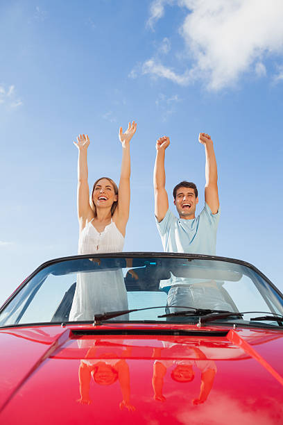 istock Cheerful couple standing in red cabriolet 500559523