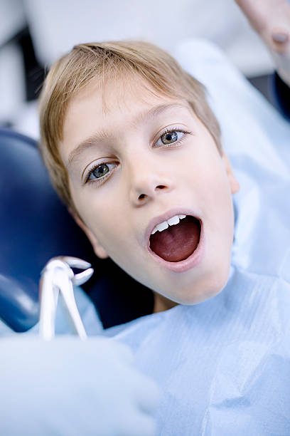terrifié garçon patient au bureau de dentiste - screaming little boys child human teeth photos et images de collection