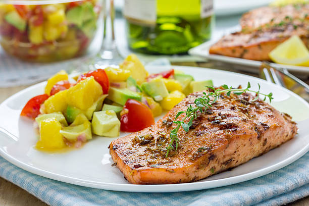 spice salmone alla griglia con salsa di mango-avocado su un piatto bianco - salmone arrosto foto e immagini stock