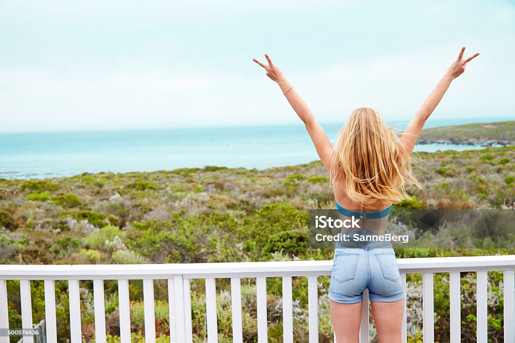 Peace loving beauty Young woman making peace sign at balcony to sea One Woman Only Stock Photo