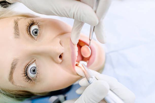 terrifié female patient au bureau de dentiste - dentist surgery dental hygiene using voice photos et images de collection