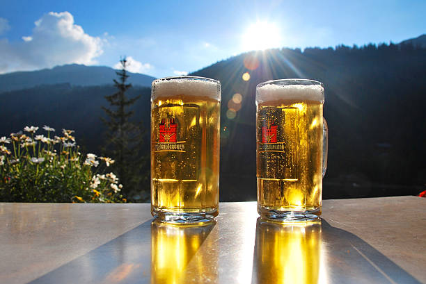 dos cervezas y un paisaje de los alpes suizos - dandelion snow fotografías e imágenes de stock