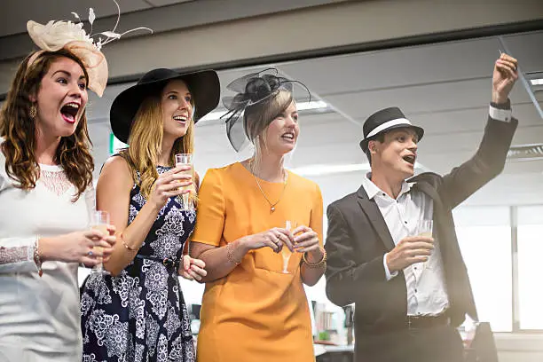 Group of Australian people very excited watching the Melbourne cup race in the office.
